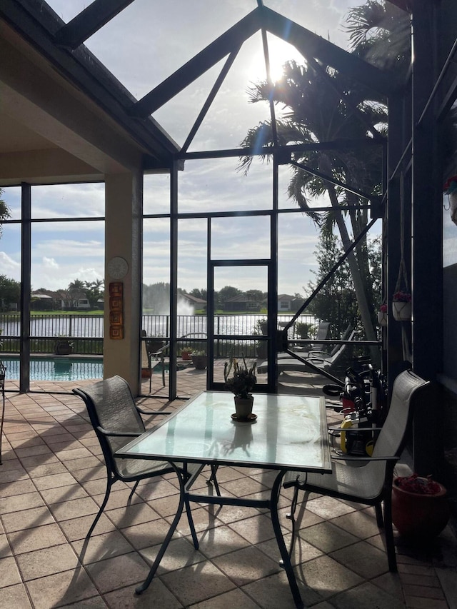 view of patio / terrace featuring a fenced in pool, glass enclosure, and a water view