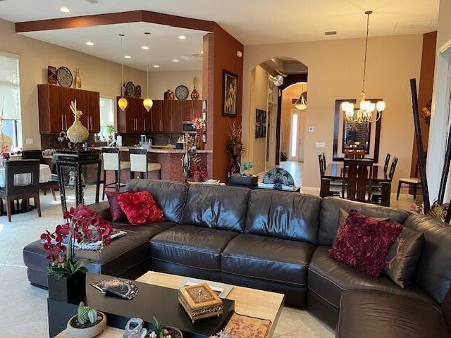 tiled living room featuring an inviting chandelier