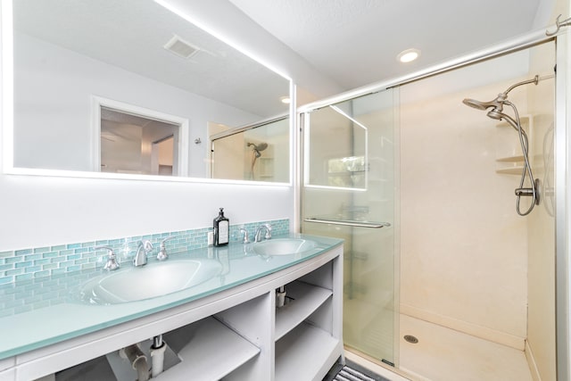 bathroom featuring vanity, a textured ceiling, and a shower with shower door