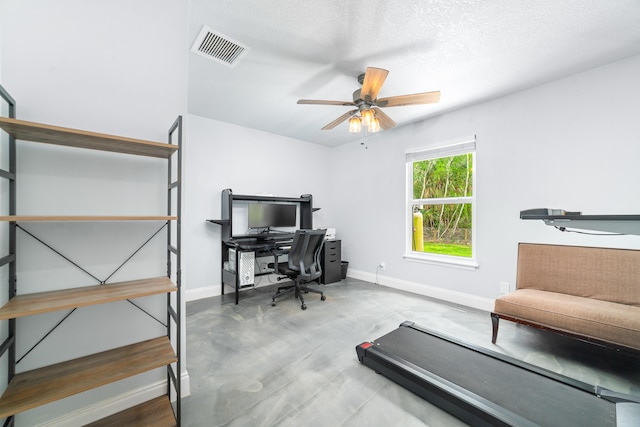 office featuring a textured ceiling, concrete flooring, and ceiling fan