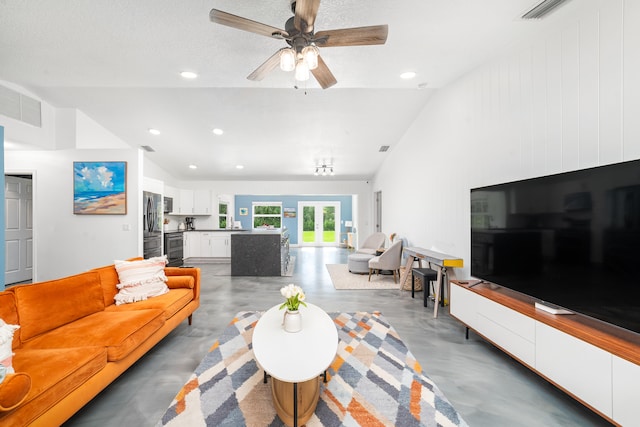 living room featuring a textured ceiling, ceiling fan, and vaulted ceiling