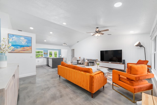 living room featuring lofted ceiling, a textured ceiling, concrete flooring, and ceiling fan