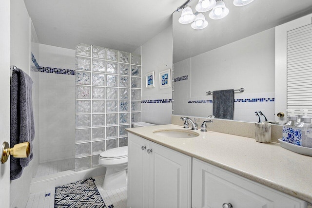 bathroom featuring toilet, vanity, tile walls, and tile patterned flooring