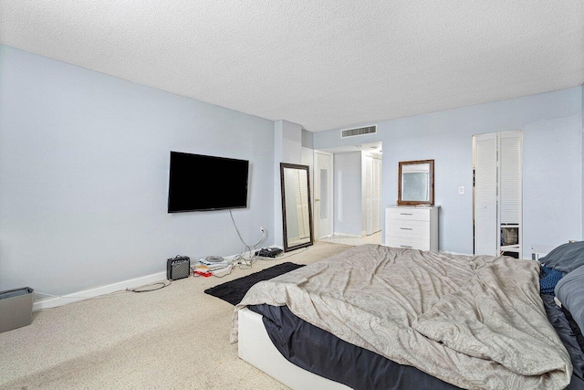 bedroom featuring light carpet and a textured ceiling