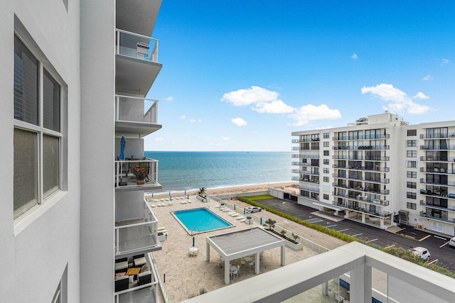 view of swimming pool with a water view and a patio area