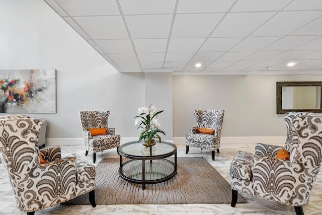 living area featuring a drop ceiling