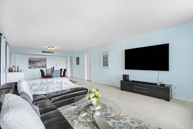 living room with a textured ceiling and light colored carpet