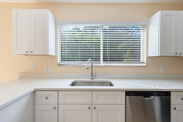 kitchen featuring white cabinetry, stainless steel dishwasher, sink, and plenty of natural light