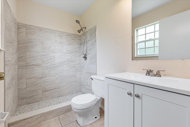 bathroom with vanity, toilet, tile patterned floors, and a tile shower