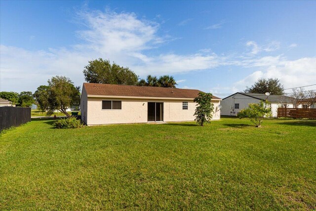 rear view of house featuring a lawn