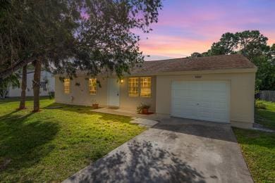 view of front facade with a garage and a lawn