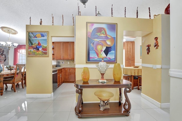 hall with a textured ceiling, an inviting chandelier, and light tile patterned floors