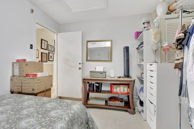 bedroom with a textured ceiling and light tile patterned flooring