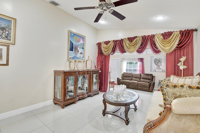 living room with vaulted ceiling, ceiling fan, a textured ceiling, and tile patterned flooring