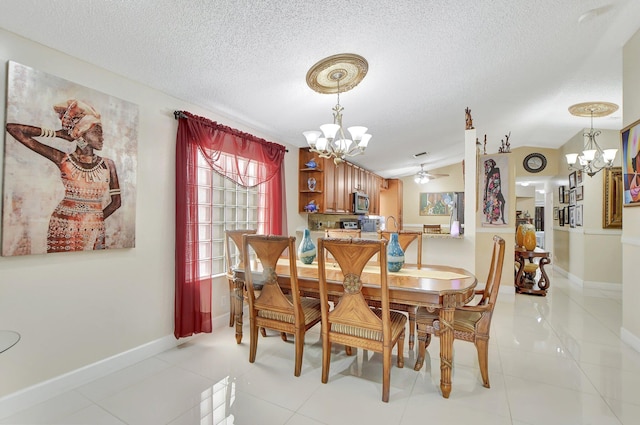 tiled dining area featuring vaulted ceiling, a textured ceiling, and ceiling fan with notable chandelier