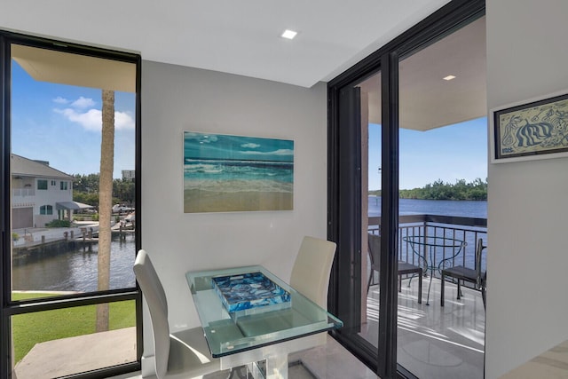 dining space featuring expansive windows and a water view