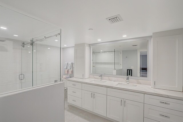 bathroom with tile patterned flooring, vanity, and walk in shower