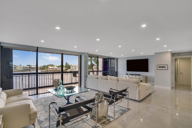 living room featuring a water view and a wall of windows