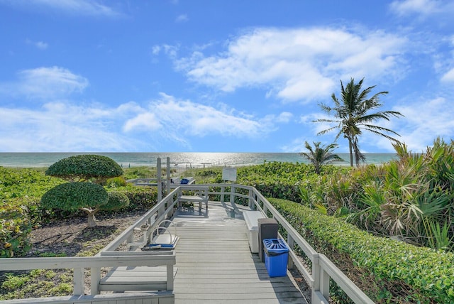 view of dock featuring a water view and a beach view