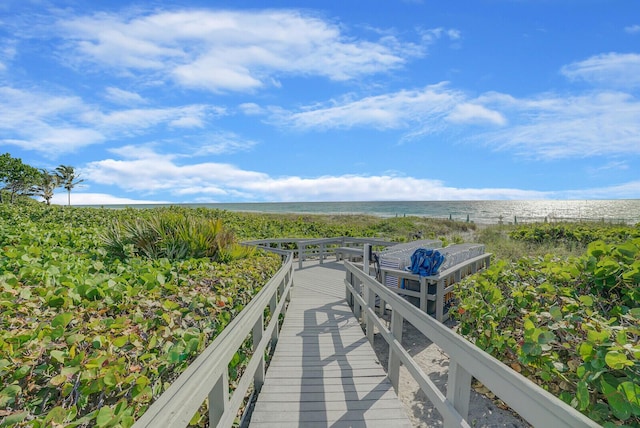 dock area with a beach view and a water view