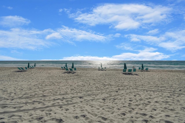 view of property's community with a beach view and a water view