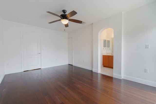unfurnished room with ceiling fan, arched walkways, baseboards, wood finished floors, and visible vents