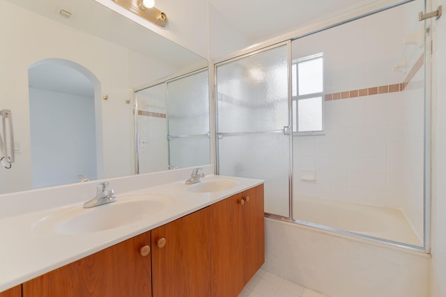 full bathroom featuring double vanity, tile patterned floors, enclosed tub / shower combo, and a sink