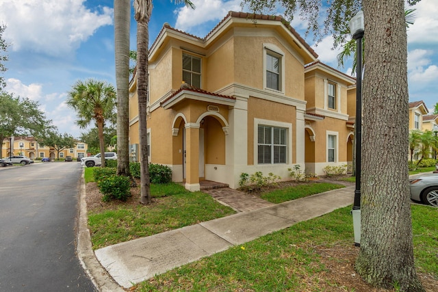 mediterranean / spanish-style house with stucco siding and a tiled roof