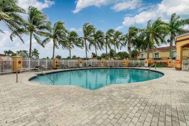 pool featuring fence and a patio