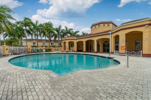 community pool with fence and a patio