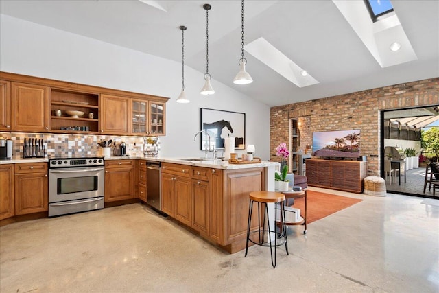 kitchen with sink, hanging light fixtures, stainless steel appliances, kitchen peninsula, and a breakfast bar area