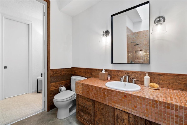 bathroom featuring vanity, toilet, and walk in shower