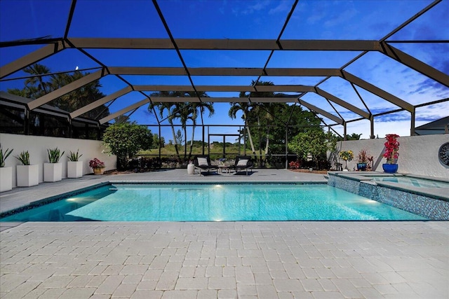 view of pool with a lanai, an in ground hot tub, and a patio