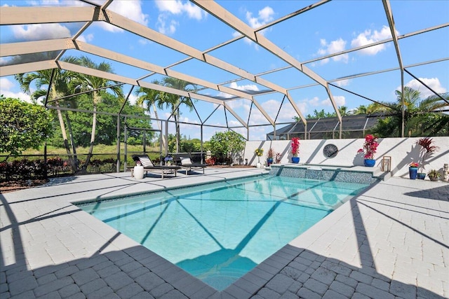 view of swimming pool featuring a patio and a lanai