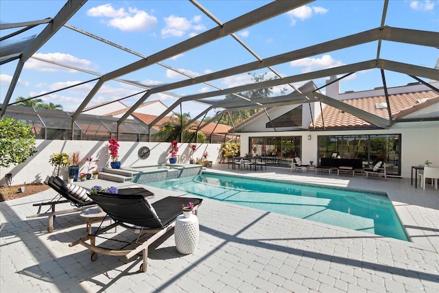 view of pool with a lanai, an in ground hot tub, and a patio