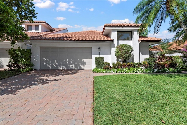 mediterranean / spanish-style home featuring a garage and a front lawn