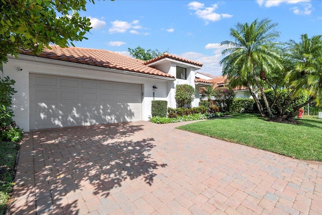 mediterranean / spanish house with a front yard and a garage