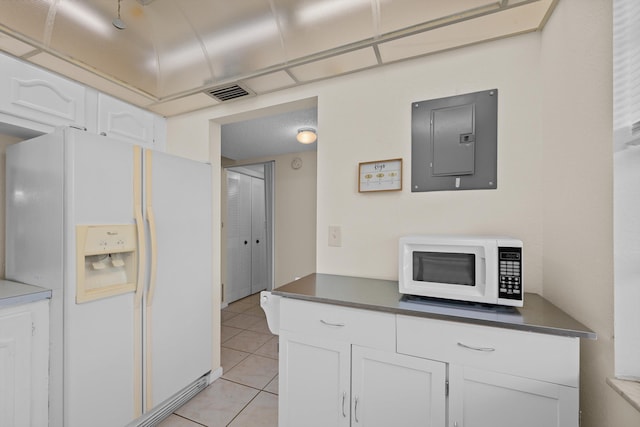 kitchen with white cabinets, white appliances, electric panel, and light tile patterned flooring