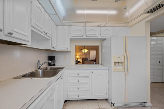 kitchen featuring sink, white cabinets, light tile patterned flooring, and white appliances