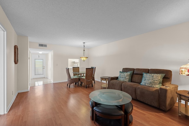 living room featuring a textured ceiling and light wood-type flooring