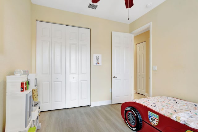 bedroom with light hardwood / wood-style floors, a closet, and ceiling fan