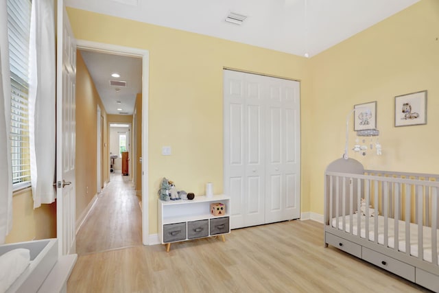 bedroom featuring a closet, multiple windows, and a nursery area