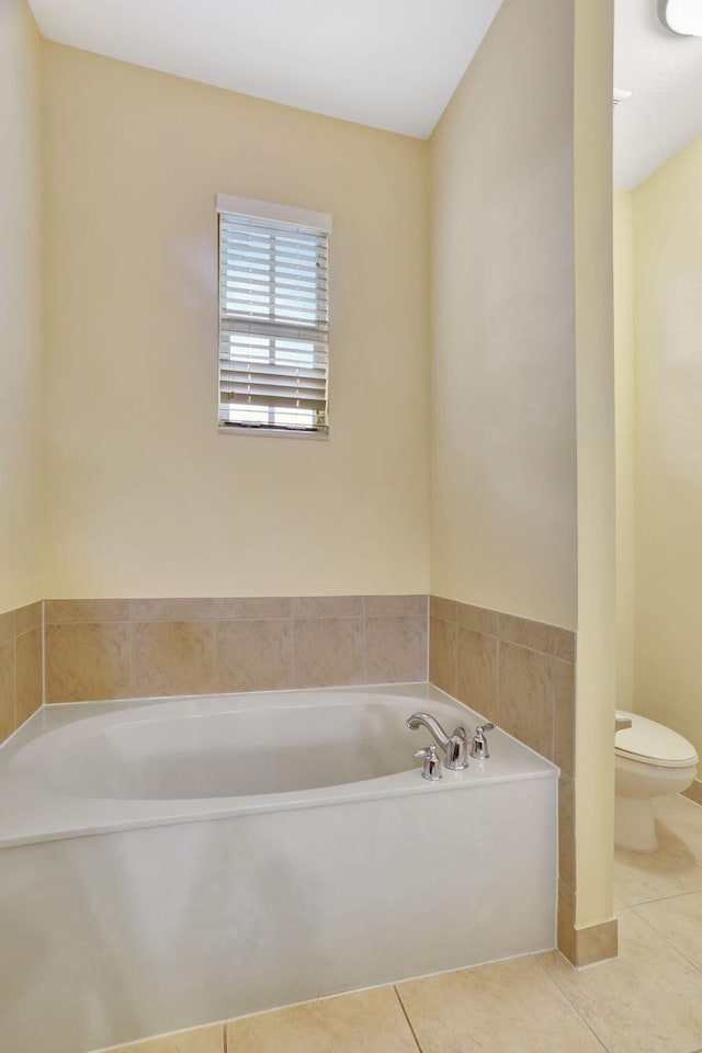 bathroom featuring toilet, a bath, and tile patterned flooring