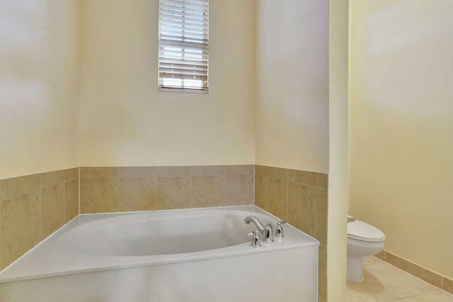 bathroom with toilet, a washtub, and tile patterned flooring