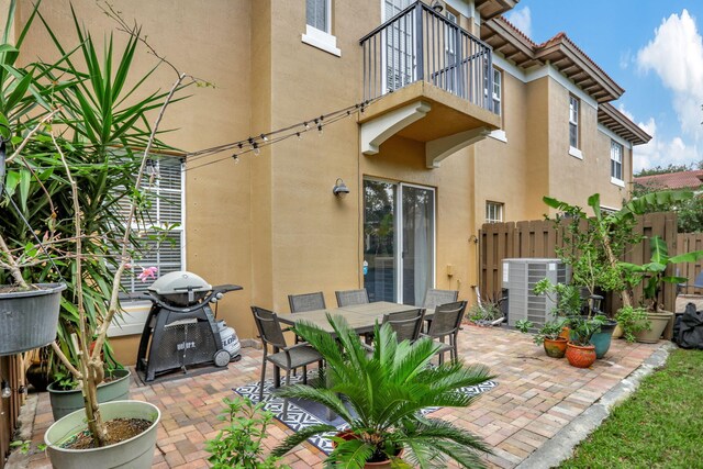 view of patio featuring central air condition unit and a balcony