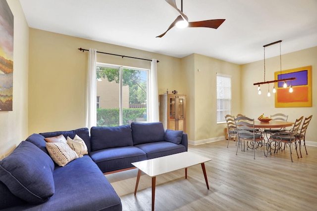 living room featuring hardwood / wood-style floors and ceiling fan with notable chandelier