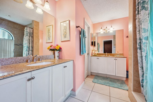 bathroom featuring vanity, a textured ceiling, walk in shower, and tile patterned flooring