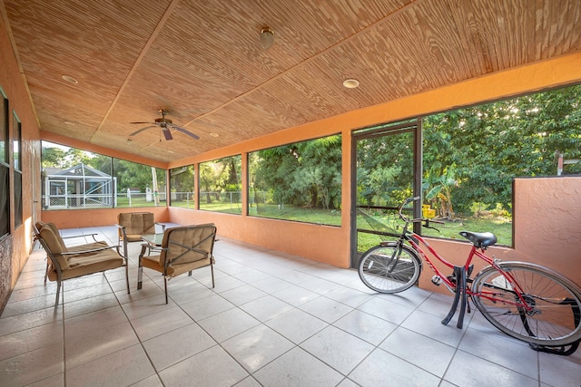 sunroom featuring wood ceiling and ceiling fan