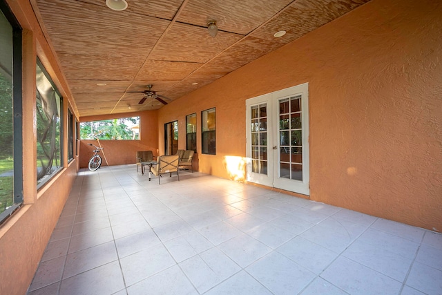 unfurnished sunroom featuring french doors and ceiling fan