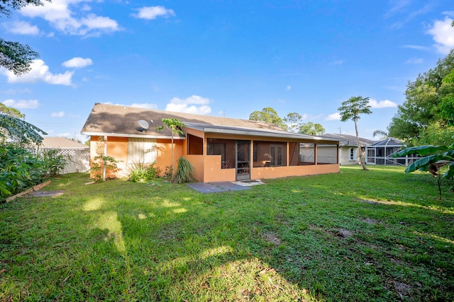 rear view of house with a lanai, a sunroom, and a lawn